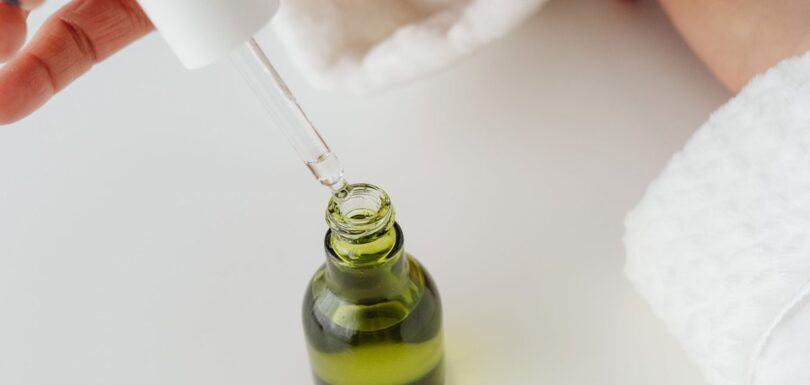 Dropper dispensing an anhydrous facial oil from a glass bottle