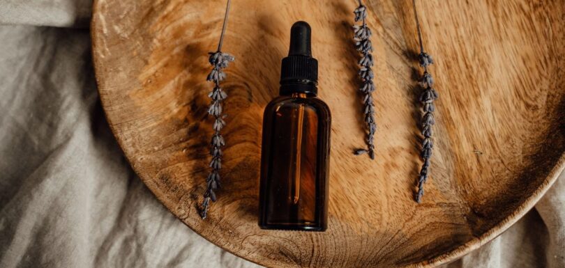 Amber glass essential oil bottles with fresh lavender sprigs on a neutral table, representing EU cosmetic and chemical regulation of essential oils