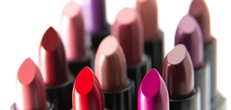A range of lipsticks and lip gloss shades arranged on a neutral background