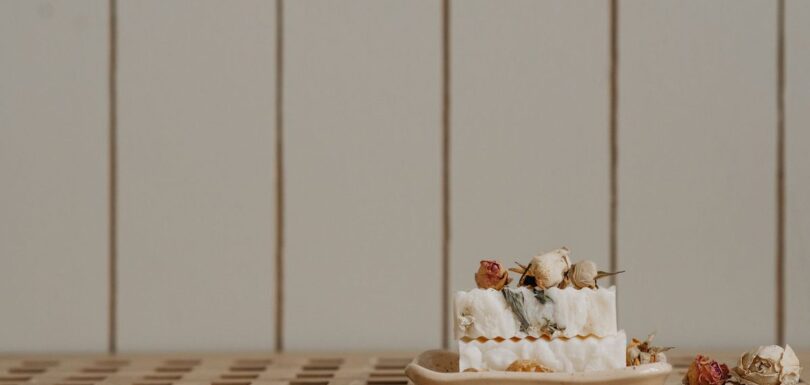 Handmade soap bars curing on a wooden rack in a small artisan workshop