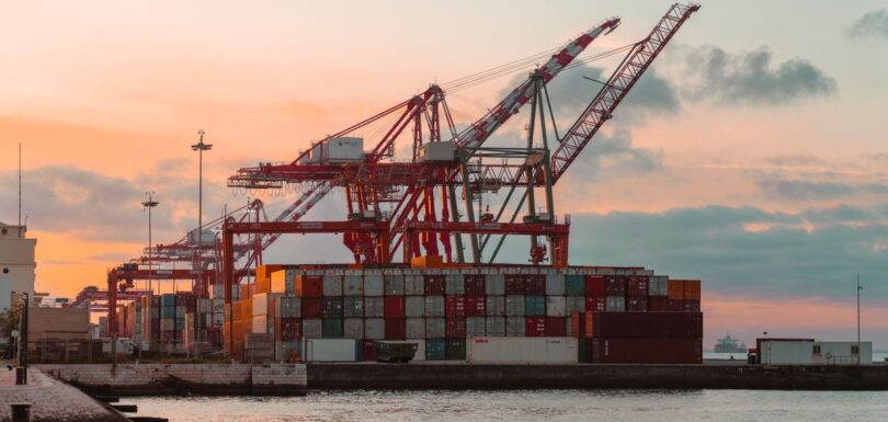 Stacked shipping containers at a European cargo port, illustrating chemical imports into the EU