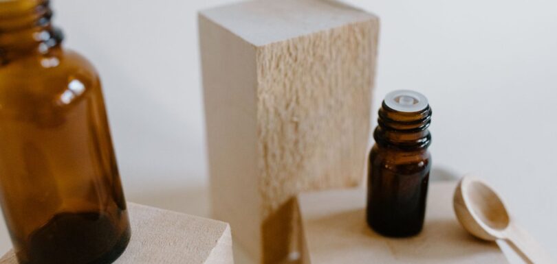 Unbranded amber dropper bottles beside a stone block, representing a cosmetic ingredient declaration