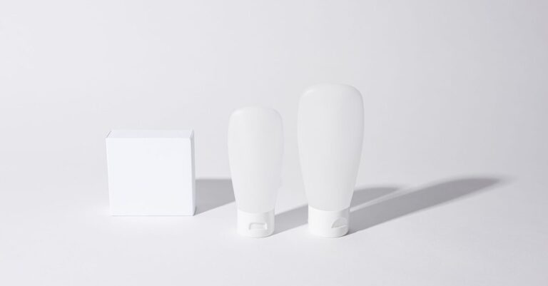 Plain unbranded white cosmetic bottles and a box