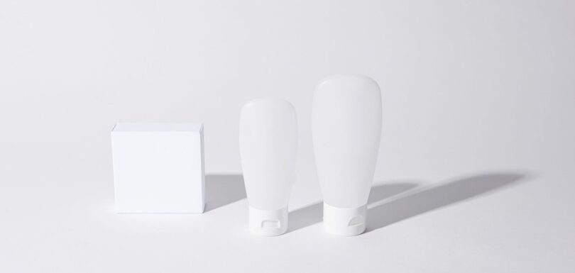 Plain unbranded white cosmetic bottles and a box