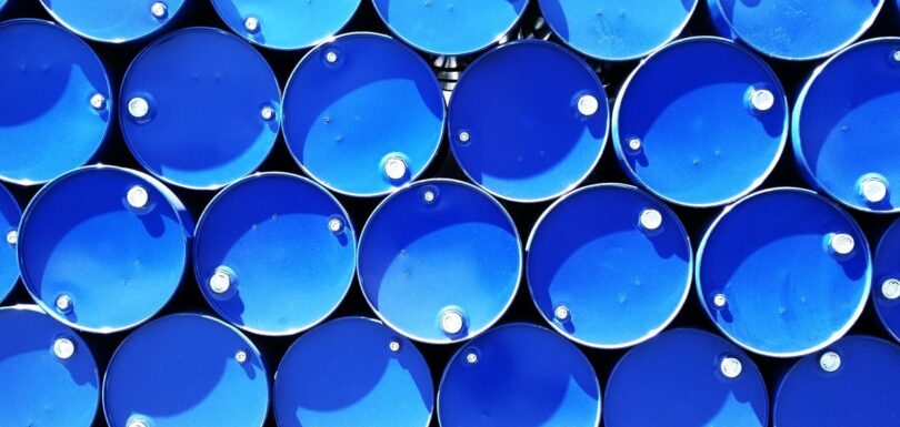 Rows of stacked blue industrial chemical drums seen from above