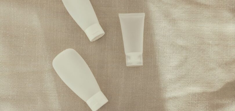 A range of unbranded cosmetic products arranged on a neutral surface