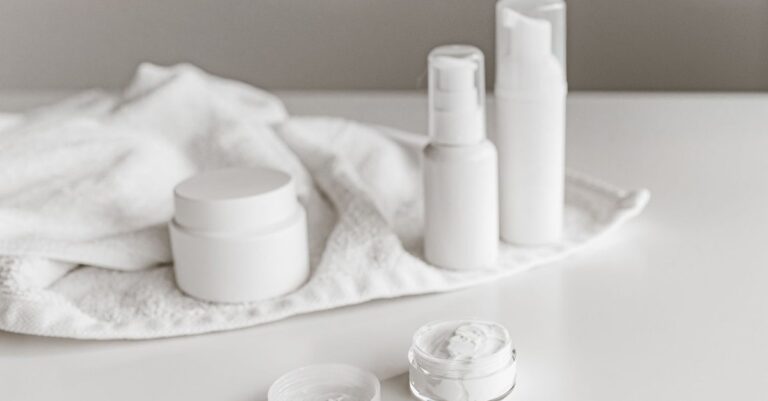 White skincare jars and bottles on a light surface