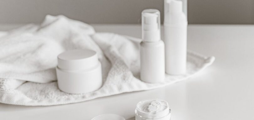 White skincare jars and bottles on a light surface