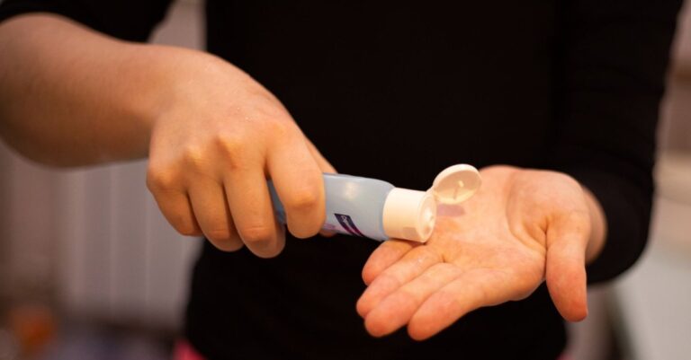 Person dispensing gel from a tube onto their palm
